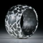 Fingerring Gabbro in Alumatrix, parallel geschliffen und bombiert, mit Karbon Innenring