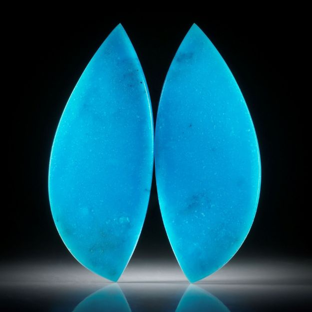 Türkis ungefärbt, 68.23ct.  Paar in asymmetrischer Navetteform, in Torsion geschliffen und beidseitig poliert, je ca.57x23x3mm