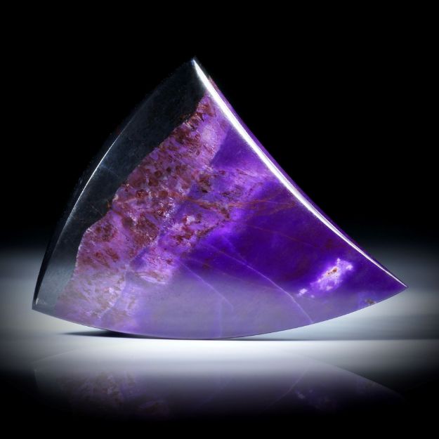 Sugilith Freiform 70.77ct.  Zahnform poliert, mit natürlichem Übergang in Manganerz, ca.42x38x7mm