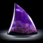 Sugilith Freiform 70.77ct.  Zahnform poliert, mit natürlichem Übergang in Manganerz, ca.42x38x7mm